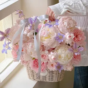Elegant white woven rattan flower basket filled with romantic pink and white flowers