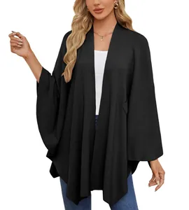 Vue détaillée d'un élégant poncho en maille noire porté par un mannequin femme