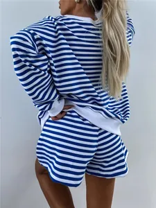 Πίσω όψη ενός casual ριγέ σετ με μπλε και άσπρο και oversized φούτερ.