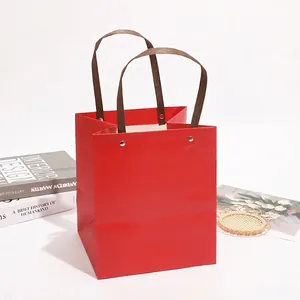 Elegant red paper gift bag with sturdy brown handles for New Year and holiday celebrations