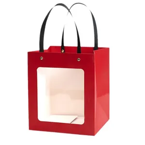 Elegant red gift bag with transparent window and black ribbon handles for festive favors