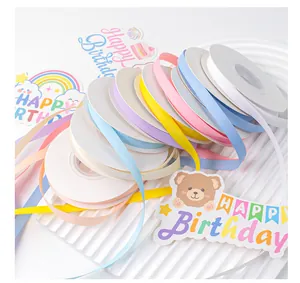 Detailed view of assorted pastel matte ribbons on spools for gift wrapping