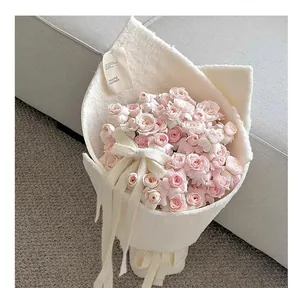 Elegant detail van zachte off-white geflokte stof voor luxe rozenboeket verpakking