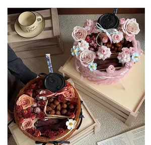 Detailed view of plush hug bucket flower and snack gift box arrangements on wood