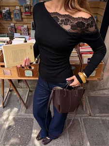Close-up detail of black French lace spliced one-shoulder long sleeve slim fit top