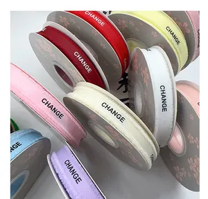 Detailed view of colorful frayed edge grosgrain ribbons with 'CHANGE' text print for gift wrapping