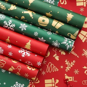 Red and green Christmas gift wrapping paper with gold and white snowflake patterns