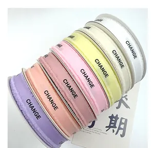 Close-up of multi-colored frayed edge grosgrain ribbons with CHANGE print