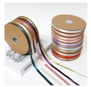 Detailed view of 1cm satin ribbons with gold edges in various colors on spools