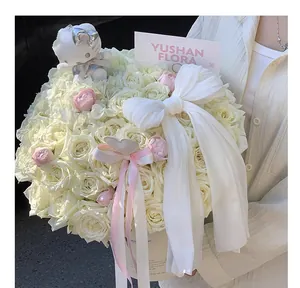 Detailed view of a luxury floral hug bucket gift box with white roses and ribbons.
