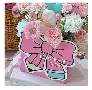 Close-up of a creative pink bow-shaped flower box with a pencil design for Teacher's Day