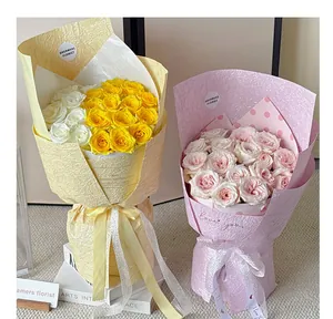 Close-up of pearlescent stone textured wrapping paper on two rose bouquets