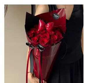 Detail shot of premium red leather flower bouquet wrap with roses and bow decor.