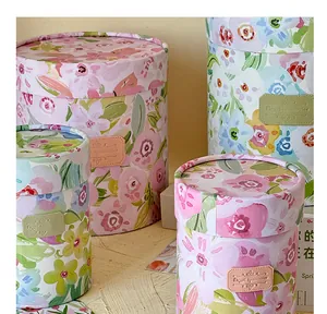 Detailed view of cylindrical gift boxes with vibrant spring floral patterns and leather labels