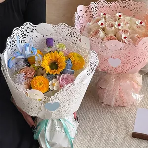 Papier d'emballage de fleurs en dentelle blanche et rose pour compositions florales.