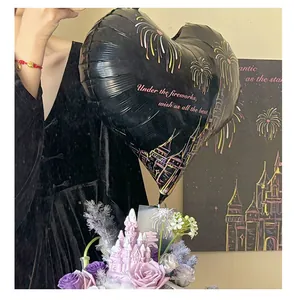Vista detallada de un globo de corazón negro con fuegos artificiales y un mensaje