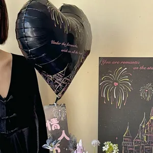 Globo de papel de aluminio negro en forma de corazón con fuegos artificiales para San Valentín