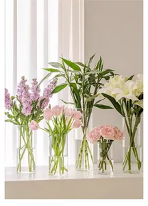 Modern set of clear acrylic cylinder flower vases with elegant floral arrangements
