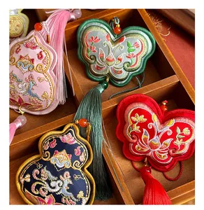 Detailed close-up of handmade Chinese style butterfly embroidered sachet with tassel