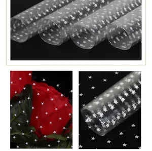 Macro view of star-patterned waterproof cellophane wrapping a red rose bouquet.