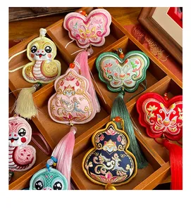 Detailed view of traditional Chinese embroidered sachets in varied colors and shapes