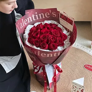 Elegant bouquet of nineteen red roses in waterproof dark red Valentine's Day wrapping paper