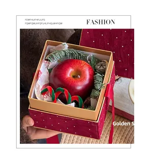 Dettaglio di una scatola regalo in velluto rosso con strass e decori festivi