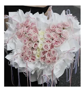 Primer plano de un arreglo floral en forma de mariposa con rosas rosas