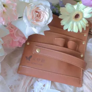 Professional brown cowhide leather florist tool bag shown in a decorative floral scene