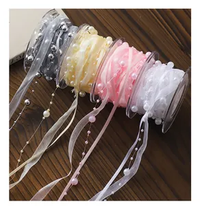 Detailed macro shot of elegant organza ribbons with integrated faux pearls in four soft colors