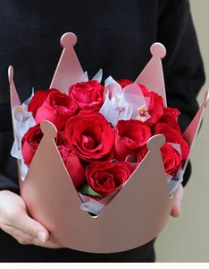 Primo piano di un'elegante scatola di fiori a corona rosa con un bouquet di rose rosse