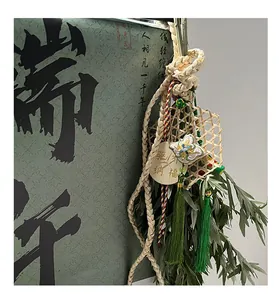 Decoración colgante de bambú para el Festival del Bote del Dragón con borlas verdes y hojas.
