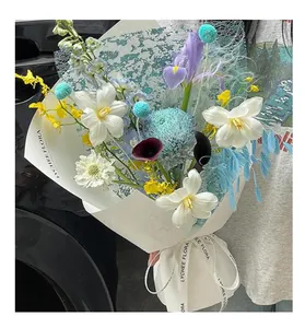 Nahaufnahme eines handgefertigten Blumenstraußes mit glitzernder Netzverpackung