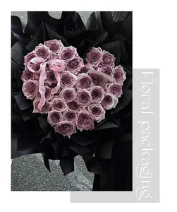 Close-up view of a heart-shaped purple rose bouquet with premium black floral packaging.