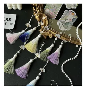 Detailweergave van gekleurde zijden kwastjes met verloop en mini waaierhangers