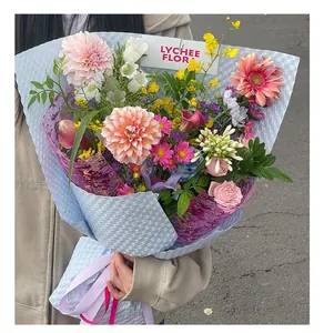 Detailansicht eines bunten gemischten Blumenstraußes mit glitzernder lila Netzverpackung