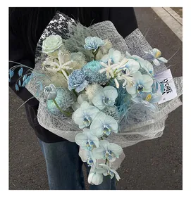 Nahaufnahme eines blauen Orchideenstraußes, eingewickelt in eleganten silbernen Netzstoff.