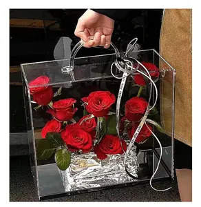 Close-up of a transparent acrylic flower gift box with handle and stylish ribbon