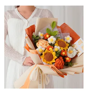 Primo piano di un bouquet di girasoli e margherite all'uncinetto con confezione regalo