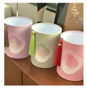 Gros plan de boîtes cadeaux décoratives avec pompons et motifs de roses