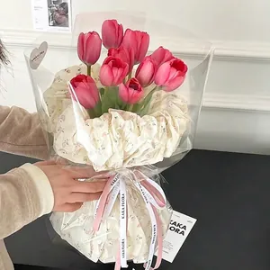 Roze tulpen gewikkeld in elegant perenpapier met rozenprint voor bloemstukken
