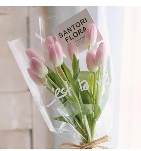 Détail du sac à fleurs transparent avec l'inscription blanche 'C'est la vie!'.
