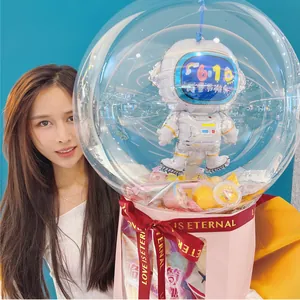 Detailed view of a creative astronaut foil balloon inside a clear snack bouquet gift box