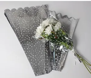 Vue détaillée des sacs d'emballage de fleurs argentés avec motif floral blanc pour roses