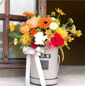 Detailed close-up of a gray round flower gift box featuring a colorful bouquet and ribbon