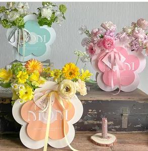 Decorative flower-shaped Mother's Day gift boxes with MOM text on a rustic wooden table