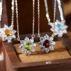 Close-up of silver sunflower pendants with natural garnet, peridot, and topaz stones.