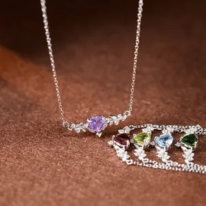 Détail de colliers en argent avec motifs de feuilles et pierres précieuses en cœur