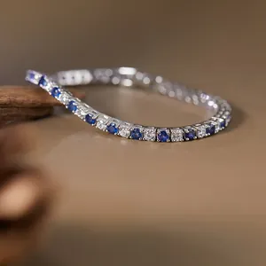 Close-up of S925 silver tennis bracelet with sapphire and sparkling white gems