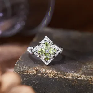 Detailed macro view of a vintage S925 silver ring set with four green peridot gemstones